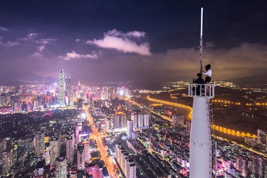 two person on white meta tower at nighttine in Sai Ge Guang Chang China
