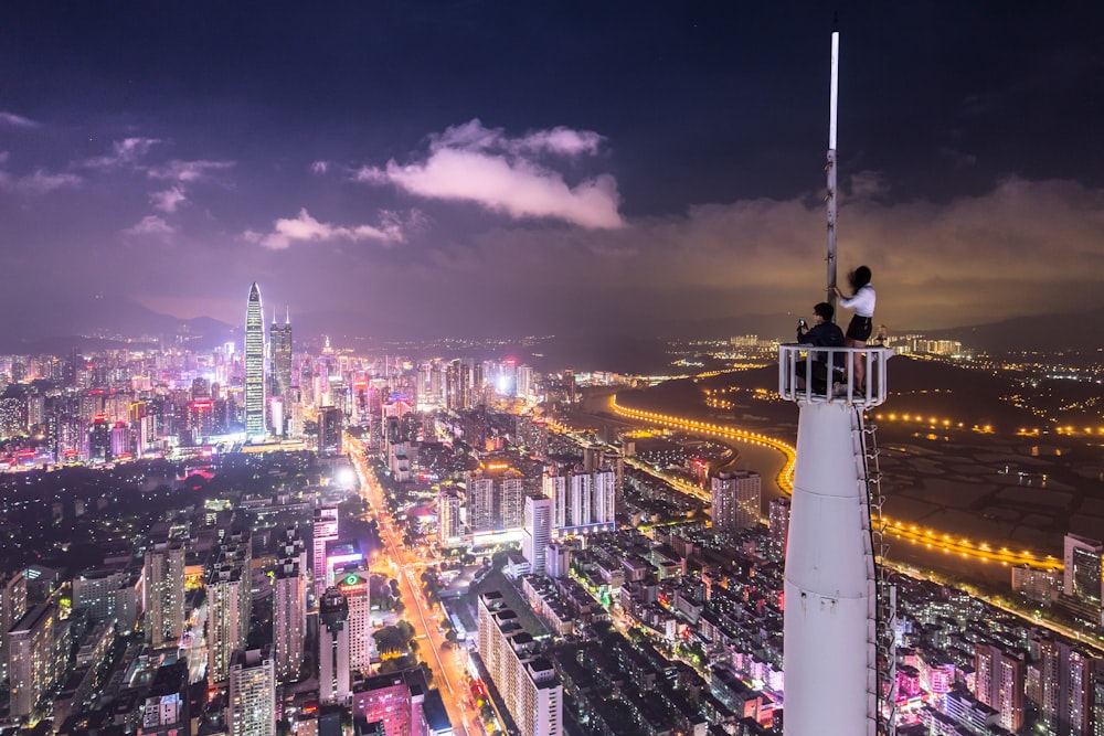 Duas pessoas na torre branca da meta no nighttine