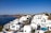 A picturesque Greek island with clear blue waters and white buildings.