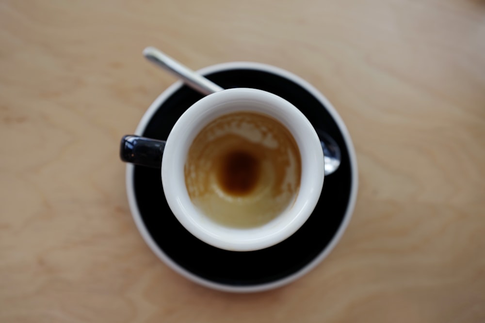 café dans une tasse sur une soucoupe à côté de la cuillère