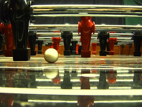 A vibrant foot table match in action, capturing players mid-game with intense focus and dynamic movement.