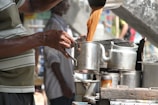 A tea stall setup with jars of jaggery and fresh tea leaves ready for brewing.