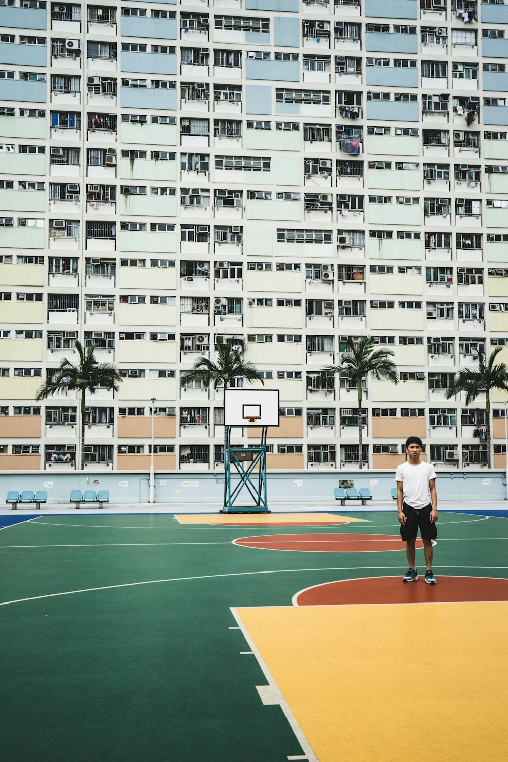 Mann steht auf Basketballplatz in der Nähe des Gebäudes