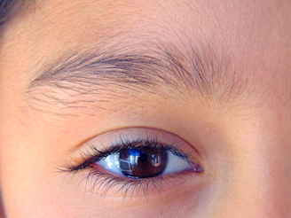 Close-up of perfectly shaped semi-permanent powder brows on a client with warm skin tone.