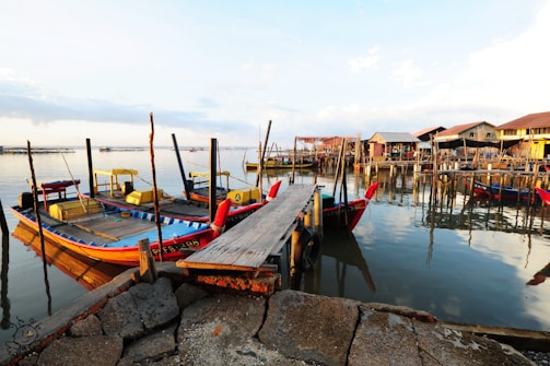 A vibrant sunrise over Labuan Bajo harbor with traditional wooden boats ready for a Komodo tour.