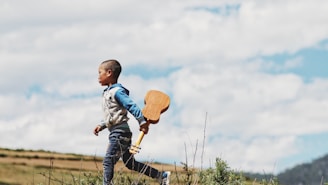 boy running while holding ukelele