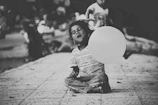 A smiling child holding a heart-shaped balloon during a health camp.