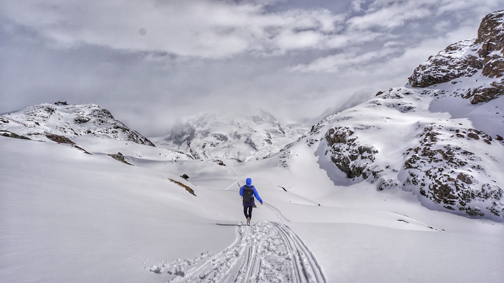 Persona caminando en la montaña nevada