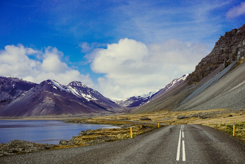 strada che va in montagna vicino allo specchio d'acqua