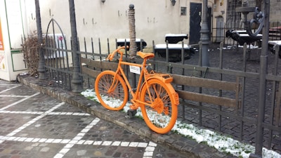 Close-up of a person locking a colorful electric bike on a sunny Caparica street