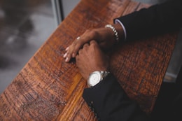person wearing black suit jacket and silver-colored watch