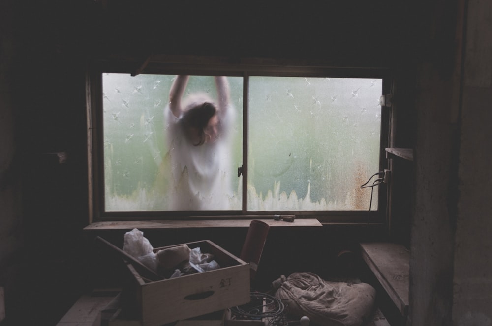 femme appuyée sur la fenêtre
