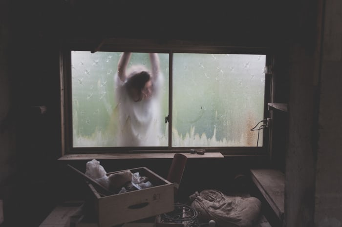 a woman standing at a basement window