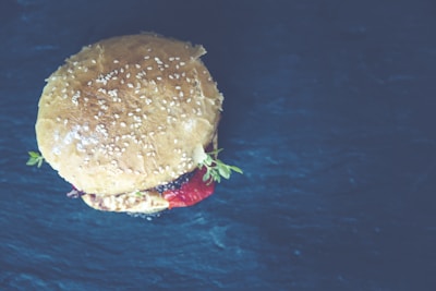 Top view of a burger with a sesame seed bun and fresh tomato slices