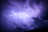 A panoramic view of a stormy sky with lightning strikes.