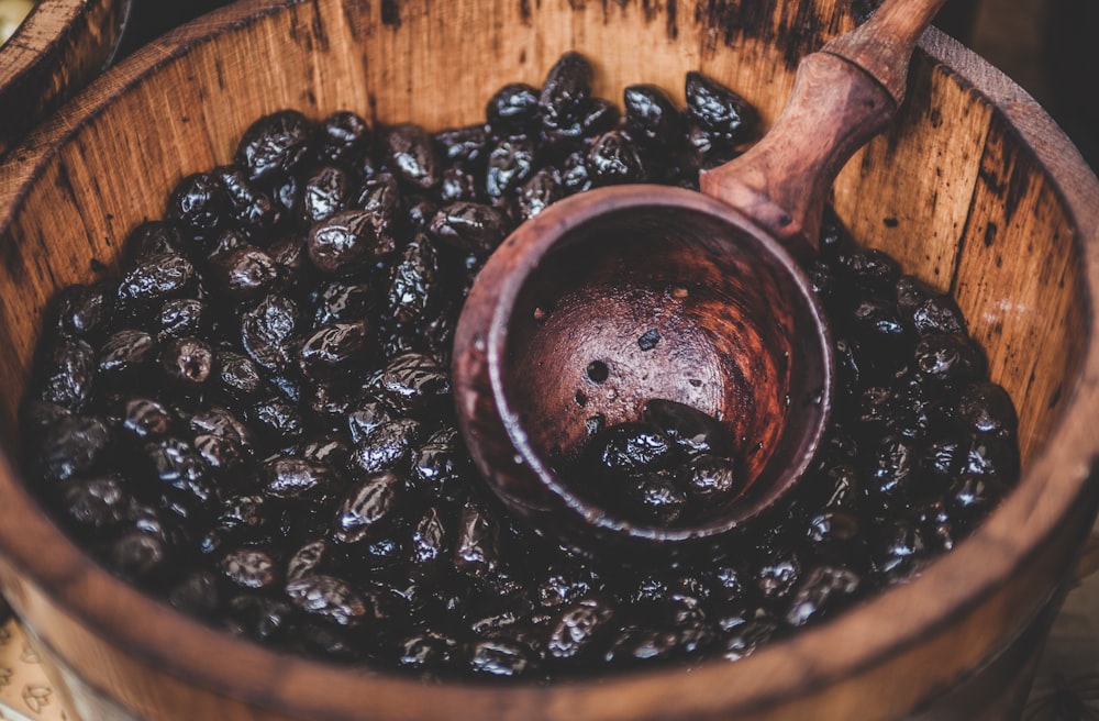 A close-up of a bucket full of cocoa beans and a wooden ladle in Cambridge.