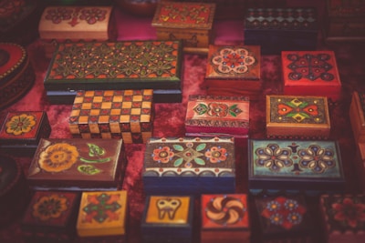 A collection of uniquely shaped creative boxes made from specialty paper, displayed with wedding favors and cultural keepsakes.