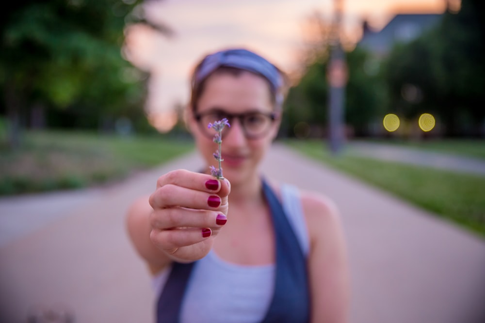 woman holding purple flower