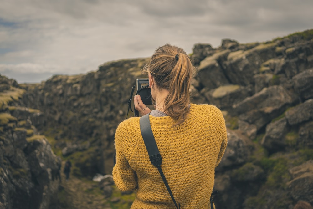 femme prenant une photo de montagne