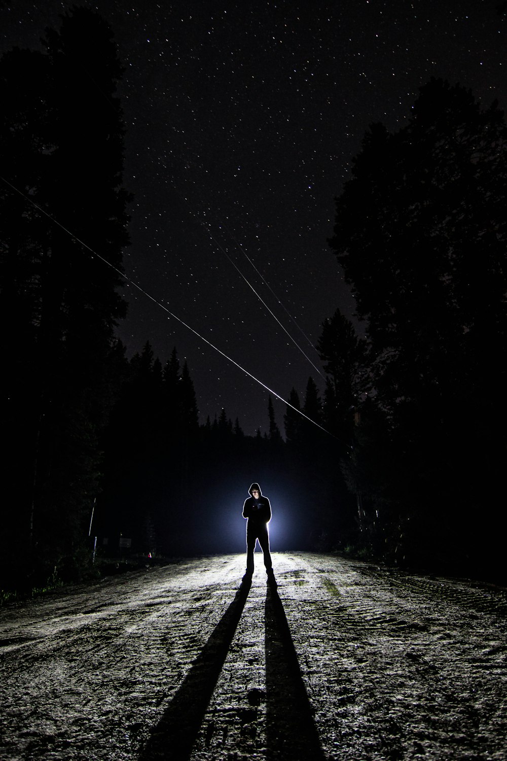 hombre de pie en el camino durante la noche