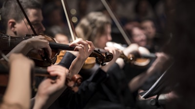 people playing violin inside dim room