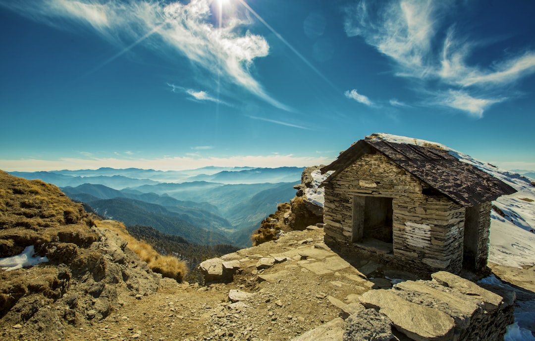 brown wooden house on mountain cliff