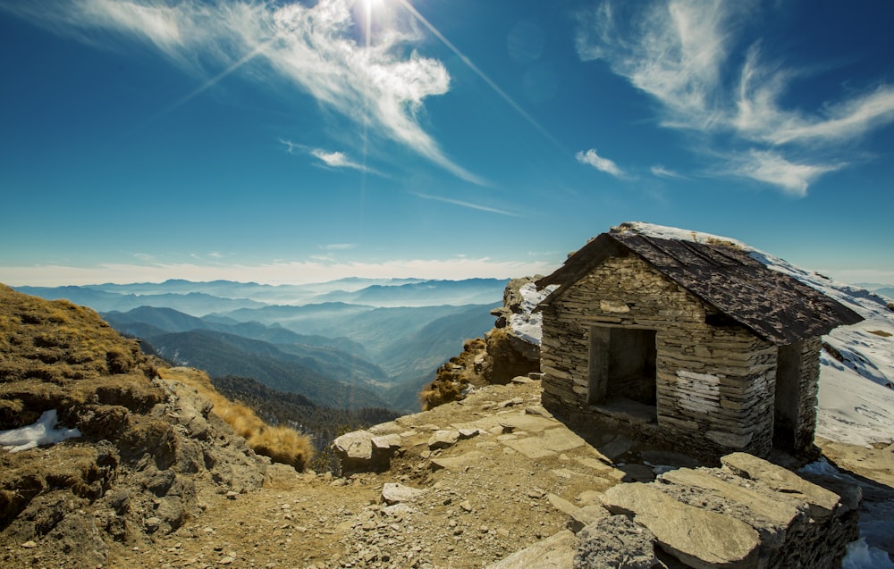 brown wooden house on mountain cliff