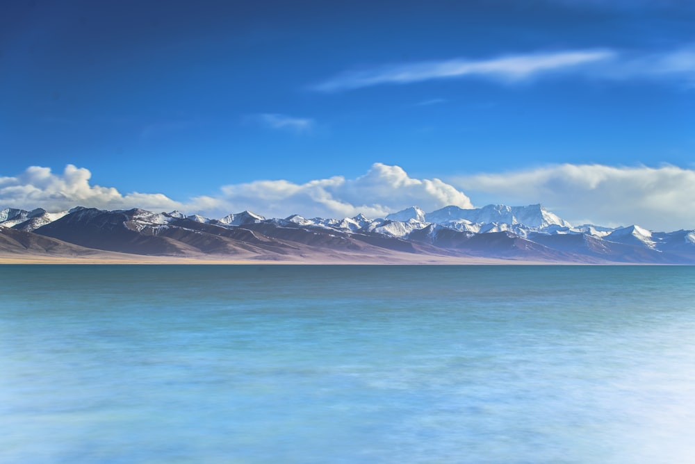 Fotografía de montaña cerca de un cuerpo de agua