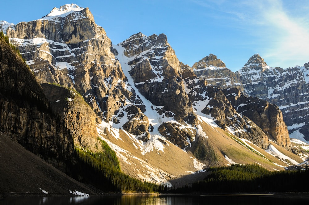 snow capped mountain near body of water