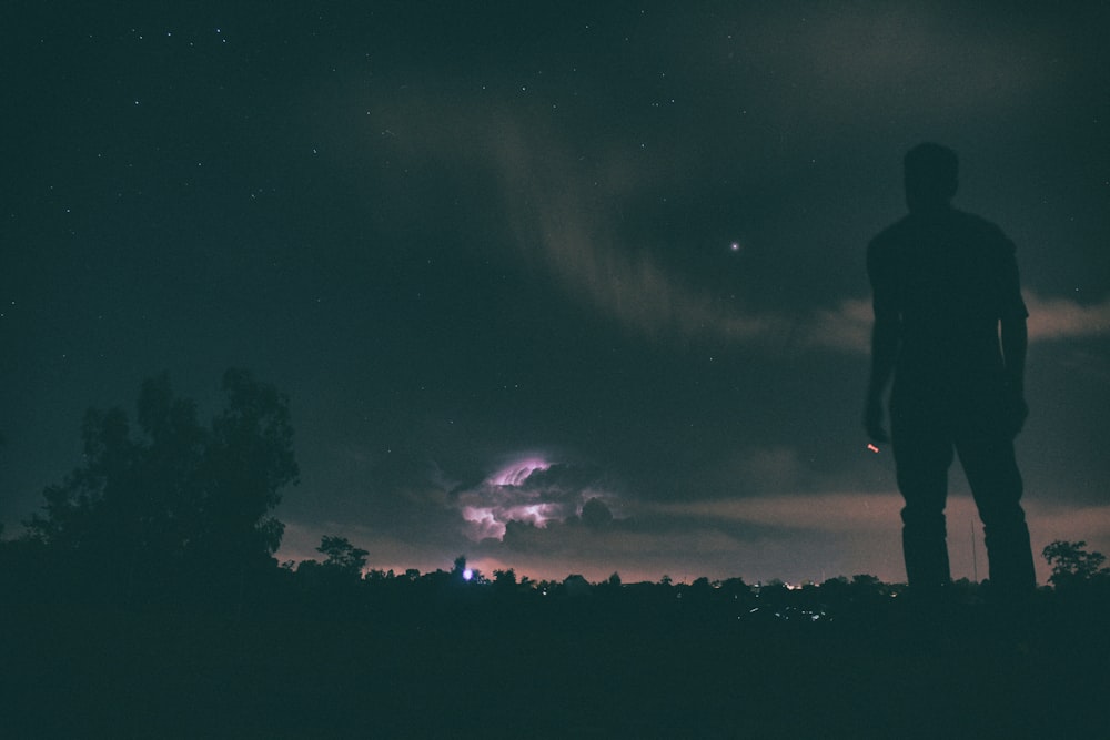 silhouette dell'uomo in piedi sotto il cielo notturno