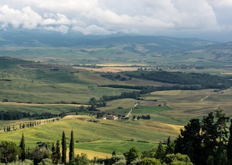 A panoramic shot of fertile farmland ready for cultivation, surrounded by lush trees.