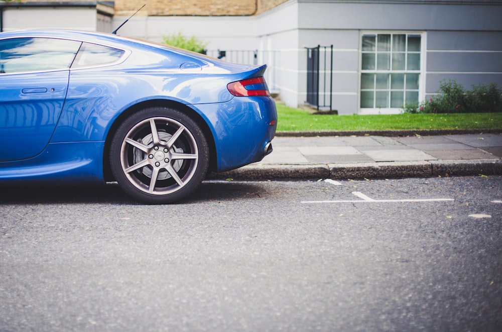 blue coupe parked in front of house