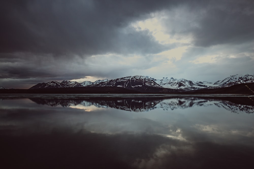 foto da paisagem do corpo de água com a montanha coberta com neve