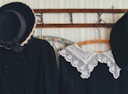 A selection of vintage clothing items hanging on a rustic rack.