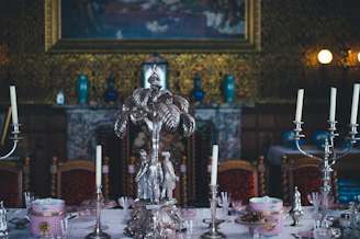 A richly set Tudor England dining table with ornate silverware and candlelight.