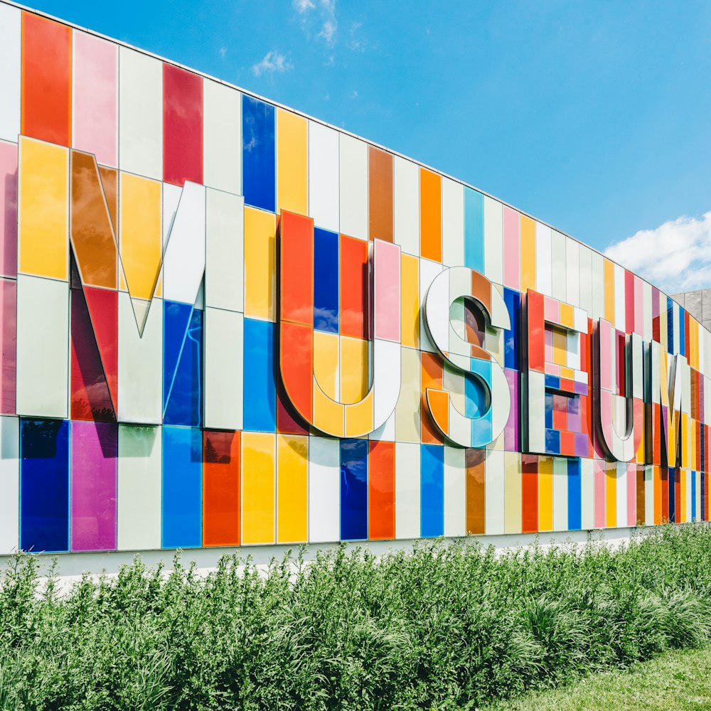 photo d’une signalétique du Musée près de plantes à feuilles vertes