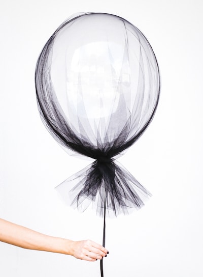 person holding black balloon decal
