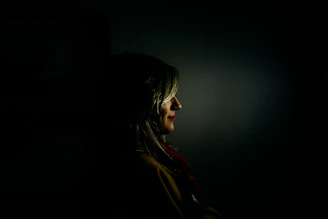 A sensual and elegant woman in soft lighting, embodying allure and mystery.