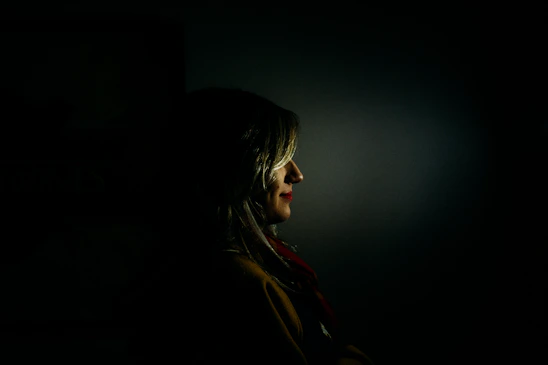 A sensual and elegant woman in soft lighting, embodying allure and mystery.