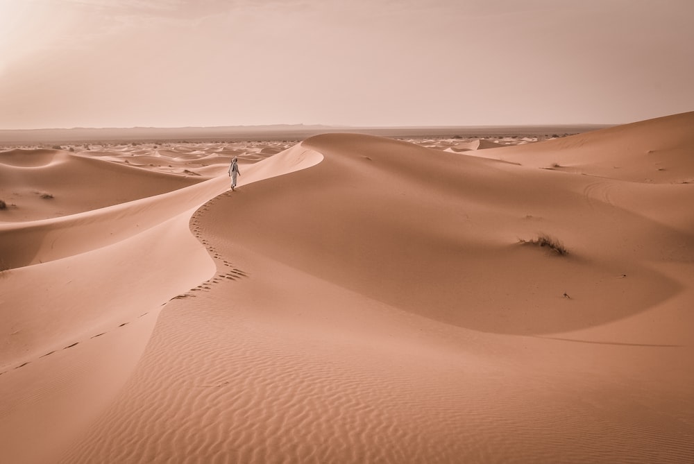 person walking on desert