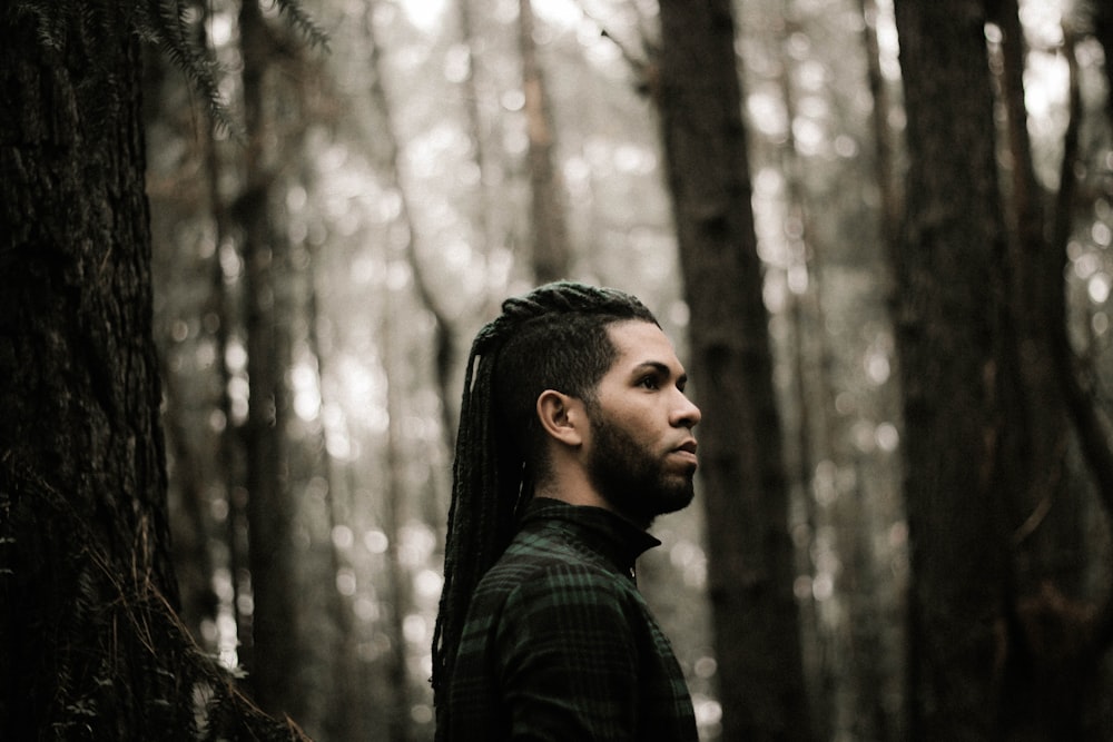 man standing beside trees