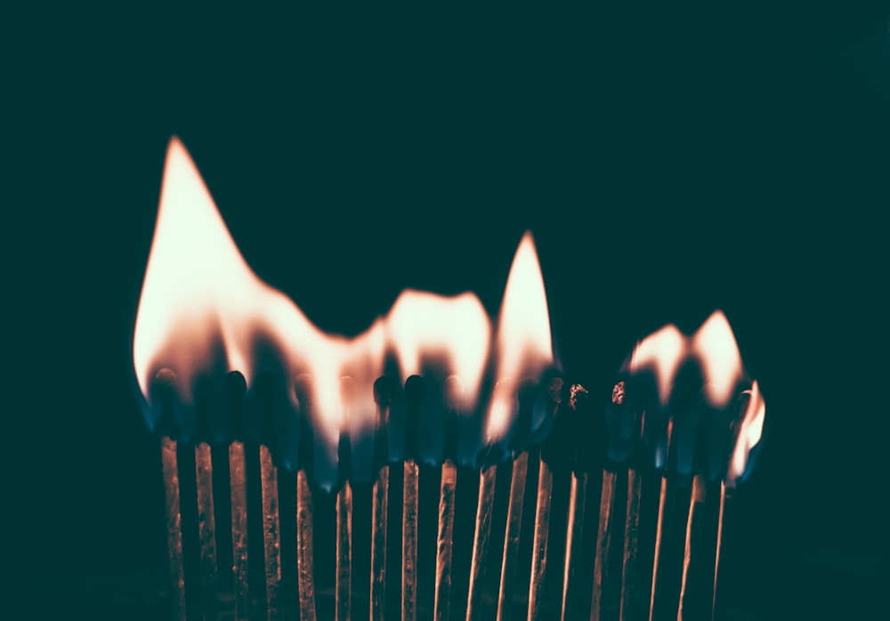 Flames ignite on a line of burning matches in the dark