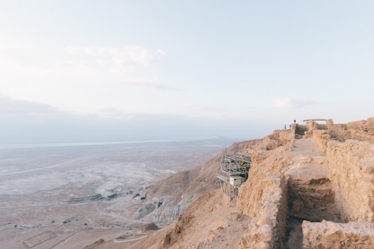 photo of gray and white construction on hill during daytime in Masada National Park Israel