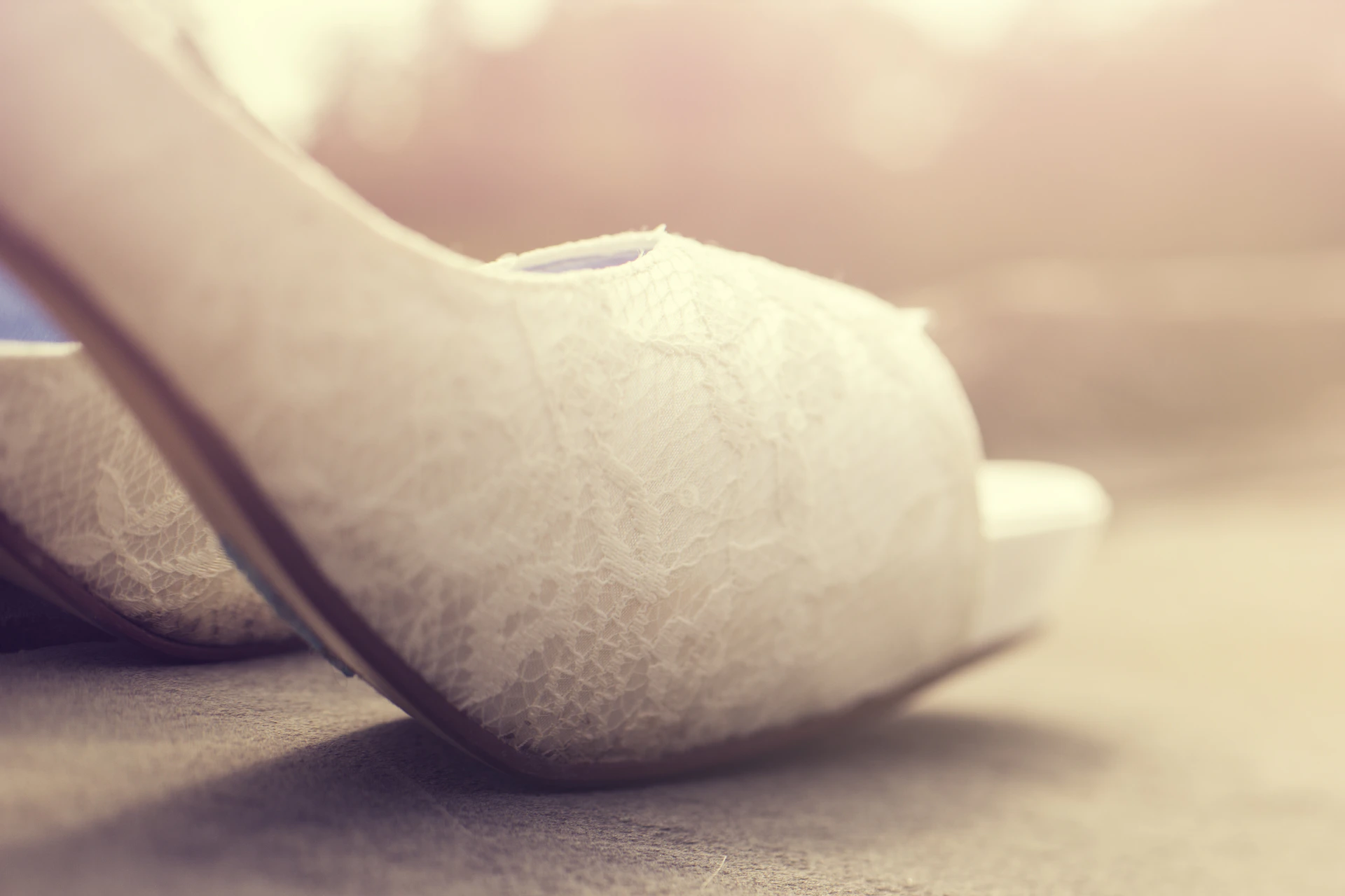 Close-up of elegant high-heeled shoes in soft pastel colors, highlighting delicate stitching details.