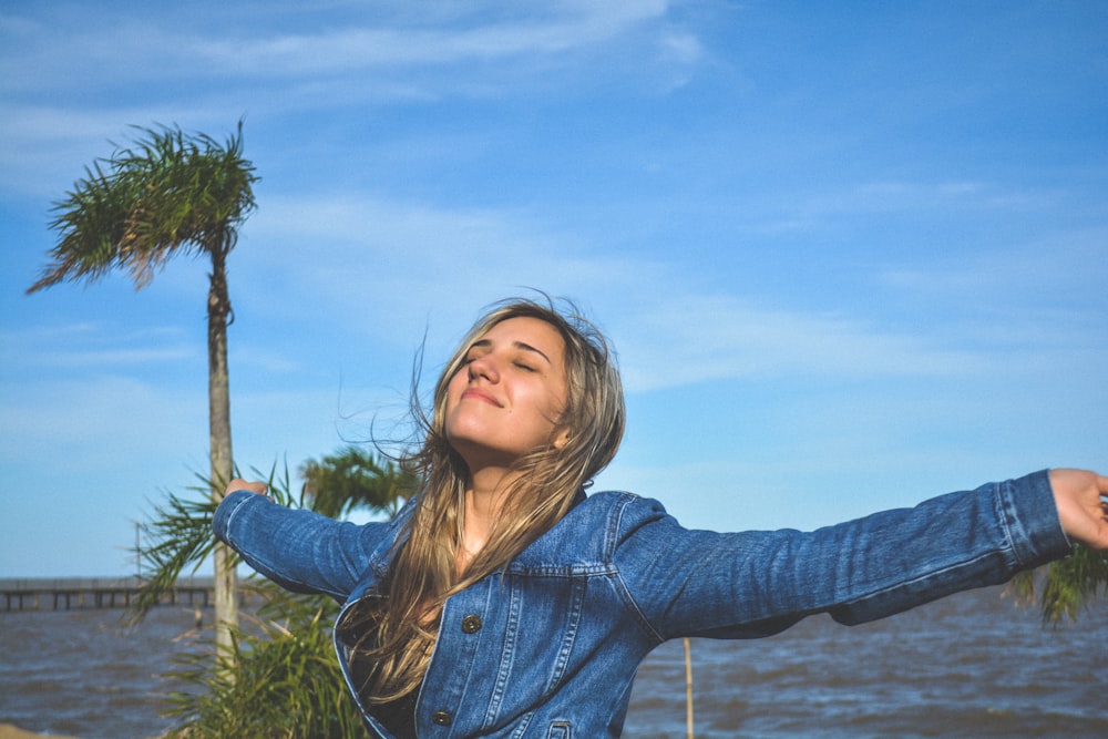 Mujer extendiendo los brazos cerca del cuerpo de agua