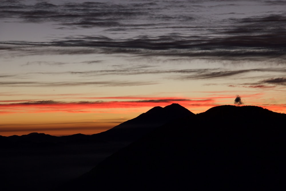 silhouette di montagna contro la luce del sole