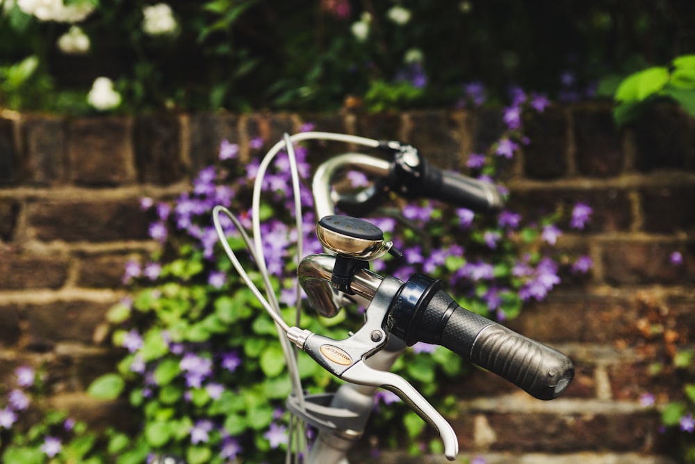 Selektive Fokusfotografie von Fahrradbremsen in der Nähe von lila Blütenblättern