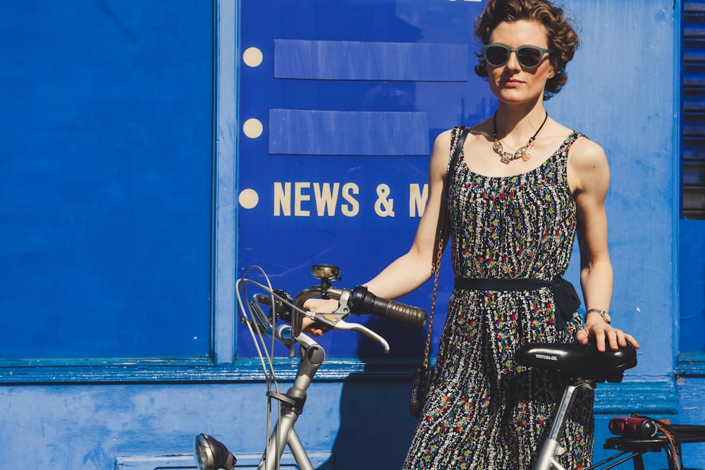 woman holding gray bicycle