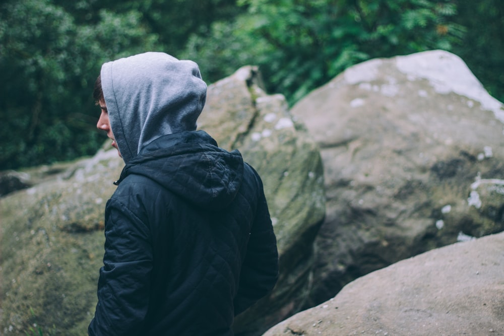 person in black hoodie near gray rocks