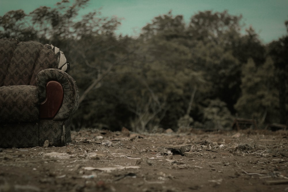 a couch sitting on top of a dirt field